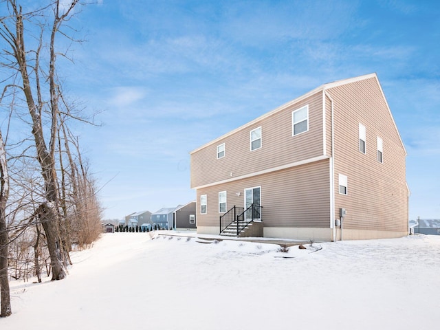 view of snow covered back of property