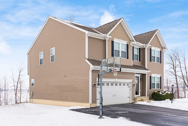 snow covered property featuring a garage