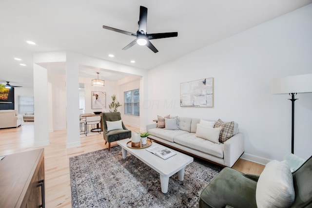 living room featuring ceiling fan and light hardwood / wood-style flooring