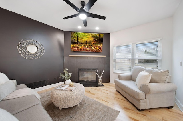 living room with ceiling fan and light hardwood / wood-style flooring