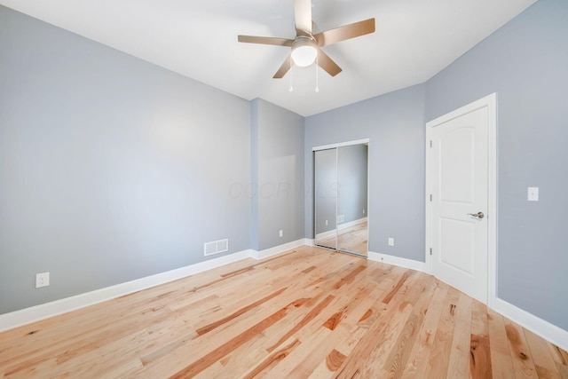 unfurnished bedroom with ceiling fan, a closet, and light wood-type flooring