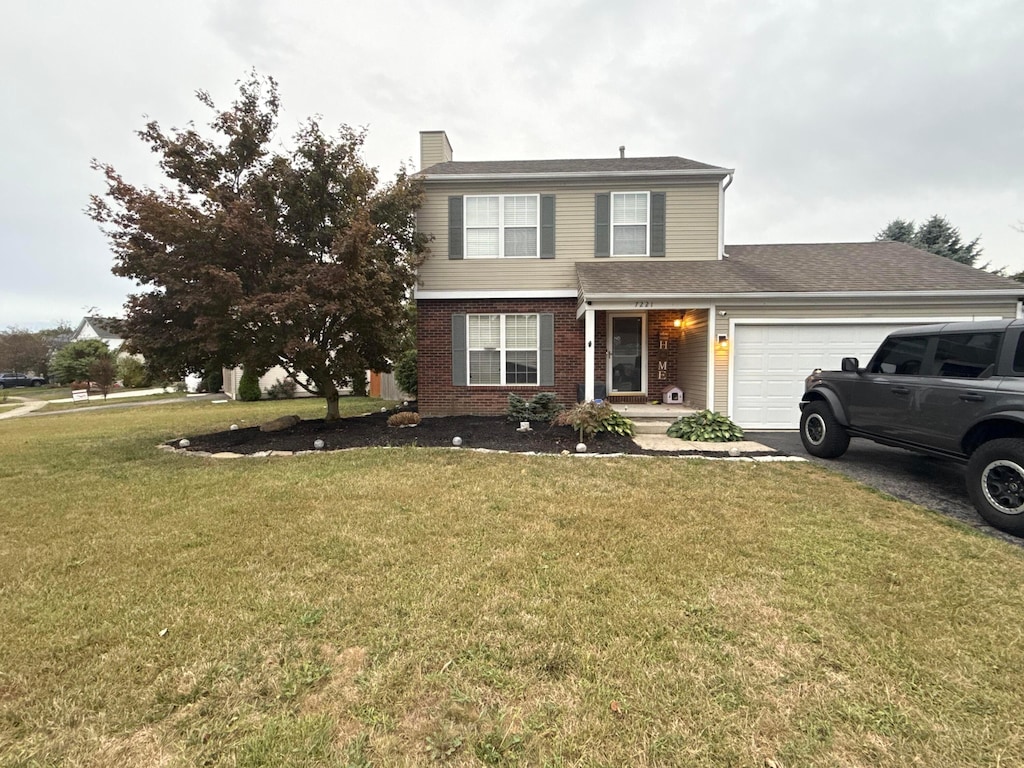 front of property with a front lawn and a garage