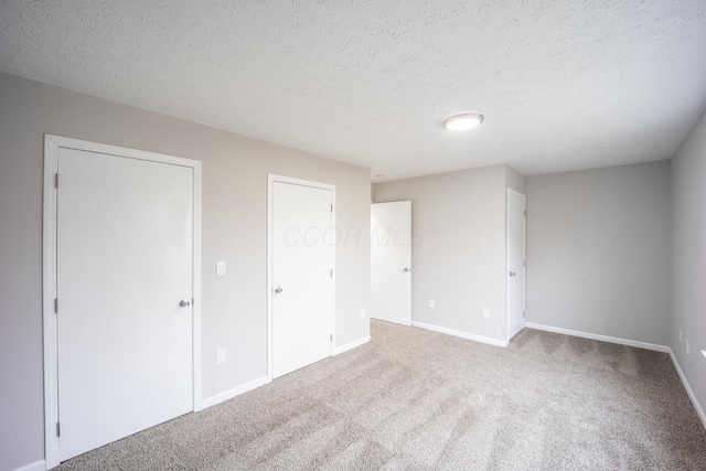 unfurnished bedroom featuring carpet floors and a textured ceiling