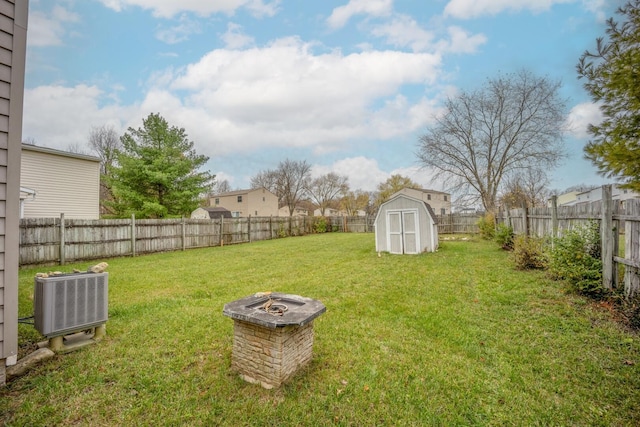 view of yard with central AC, a fire pit, and a storage unit