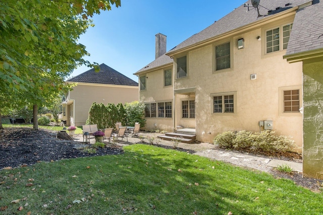 rear view of property featuring a lawn and a patio