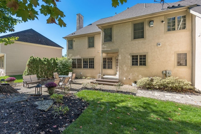 rear view of property with a lawn and a patio