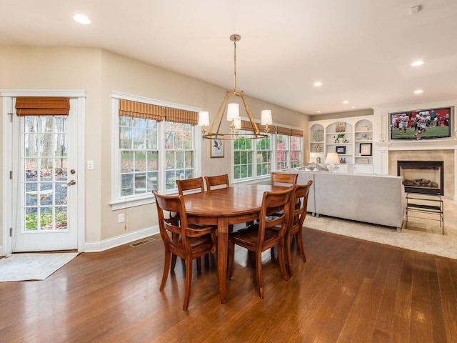 dining space with a healthy amount of sunlight, hardwood / wood-style floors, and built in shelves