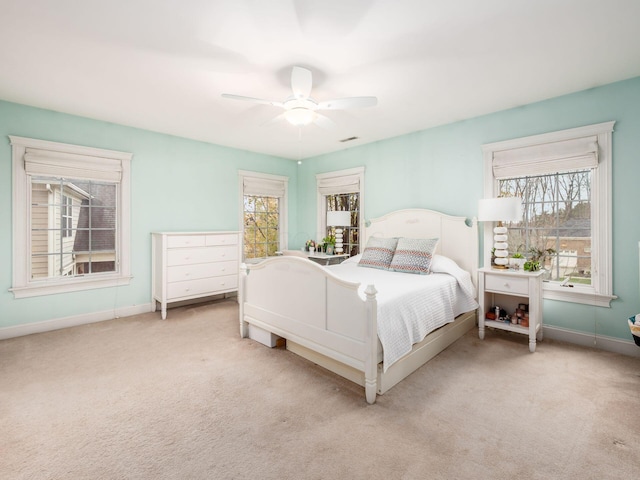 carpeted bedroom featuring ceiling fan and multiple windows