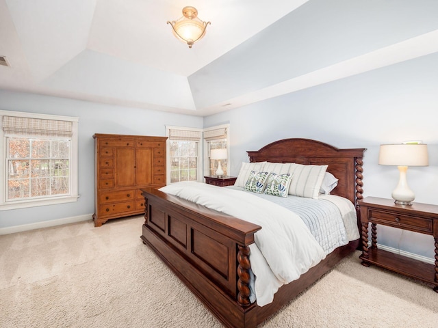 carpeted bedroom with a tray ceiling