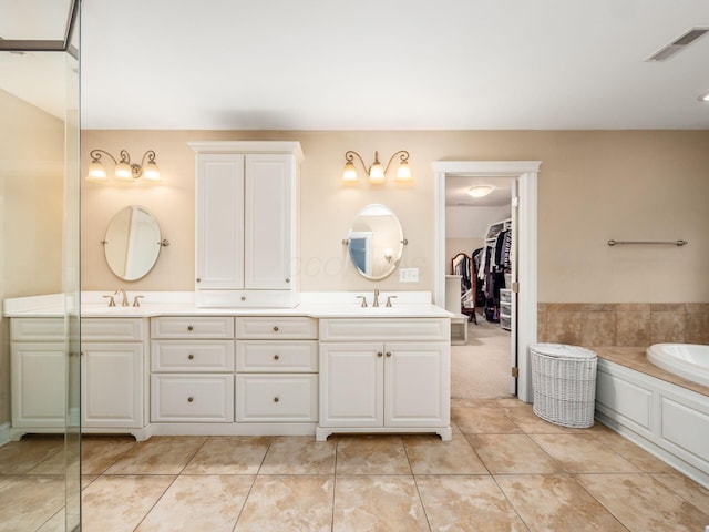 bathroom featuring a washtub, tile patterned floors, and vanity