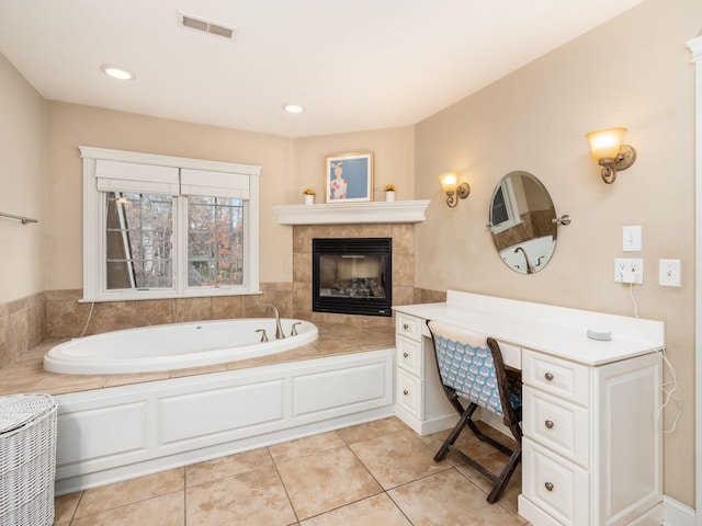 bathroom with a washtub, tile patterned flooring, and a fireplace