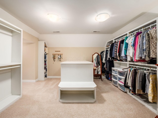 spacious closet featuring light colored carpet and vaulted ceiling