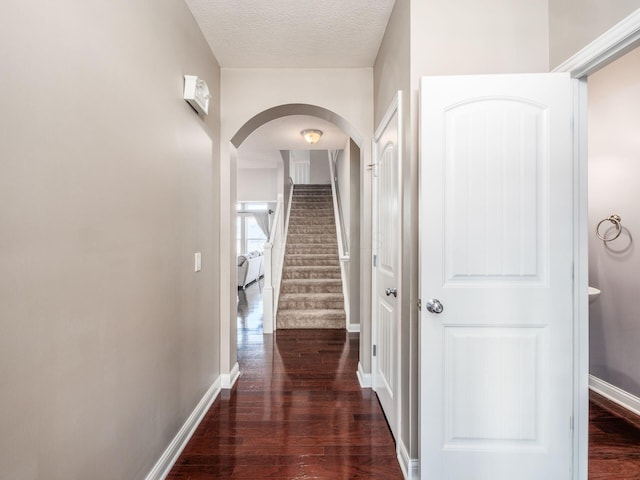 hallway featuring dark hardwood / wood-style floors and a textured ceiling