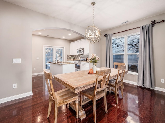 dining area with dark hardwood / wood-style flooring and a chandelier