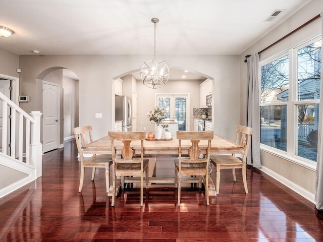 dining space featuring dark hardwood / wood-style flooring and a notable chandelier