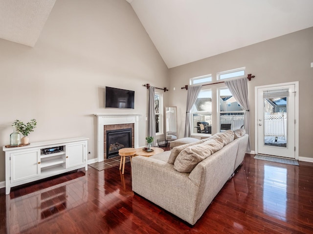 living room with high vaulted ceiling, a fireplace, and dark wood-type flooring