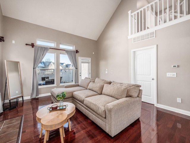 living room featuring high vaulted ceiling and dark wood-type flooring