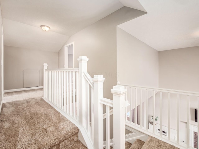 corridor featuring light carpet and vaulted ceiling