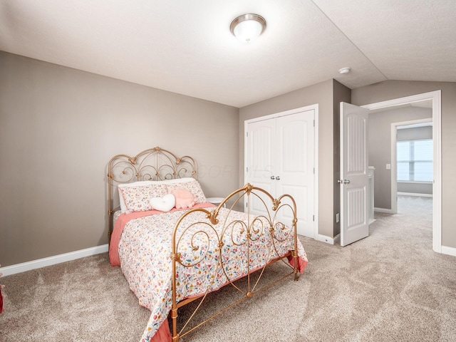 carpeted bedroom featuring lofted ceiling and a closet