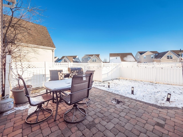 snow covered patio with a grill