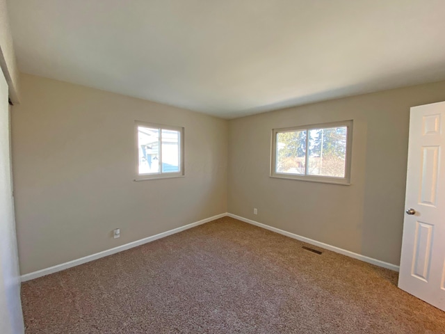 unfurnished bedroom featuring carpet floors, baseboards, and visible vents