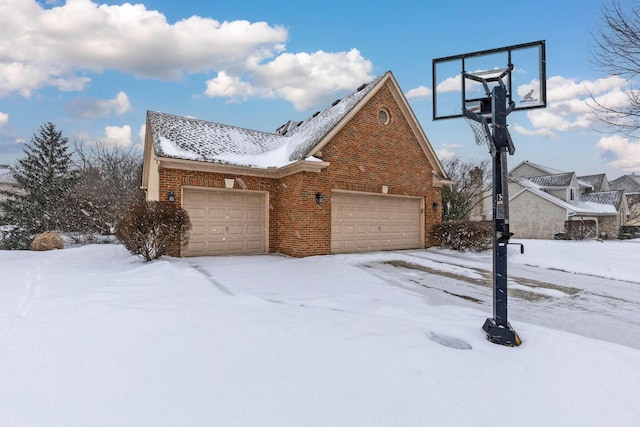 snow covered property featuring a garage