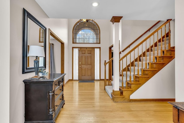 entrance foyer with a high ceiling, a chandelier, and light wood-type flooring