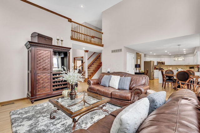 living room with light hardwood / wood-style floors and a high ceiling