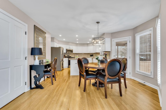 dining room featuring an inviting chandelier and light hardwood / wood-style floors