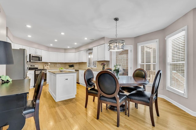 dining room with a notable chandelier and light wood-type flooring