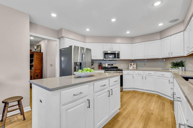 kitchen with white cabinets, backsplash, and appliances with stainless steel finishes