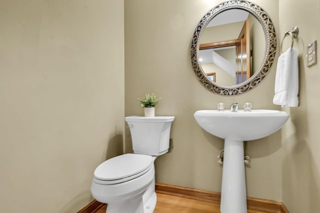 bathroom with hardwood / wood-style floors and toilet