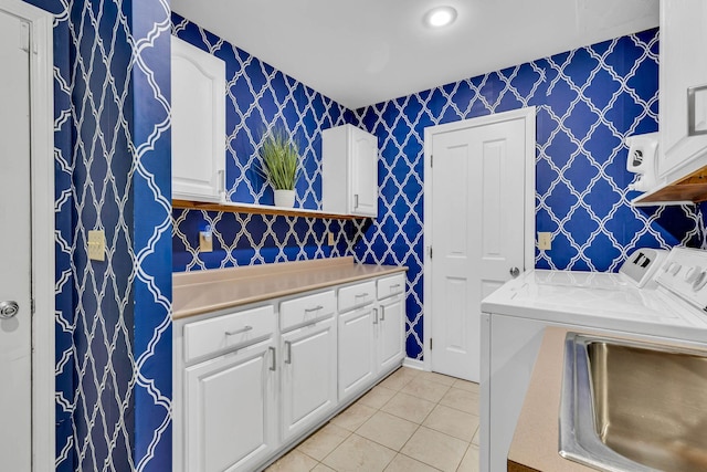 laundry area with washing machine and dryer, cabinets, light tile patterned flooring, and sink