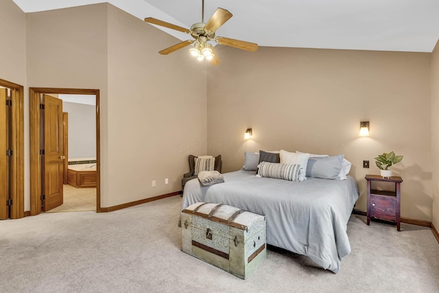 bedroom featuring lofted ceiling, ensuite bath, ceiling fan, and light colored carpet