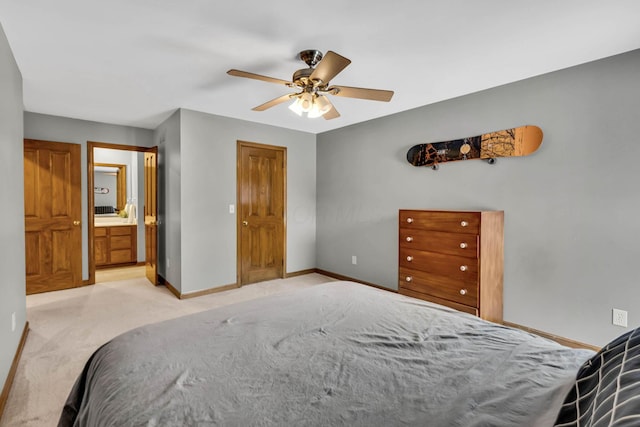 bedroom with ceiling fan, connected bathroom, and light carpet