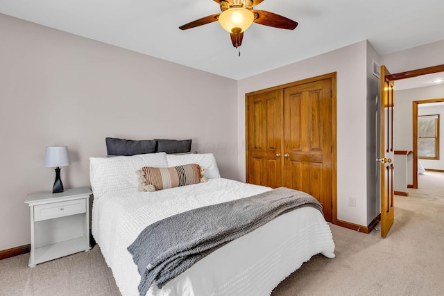 bedroom featuring ceiling fan, light colored carpet, and a closet