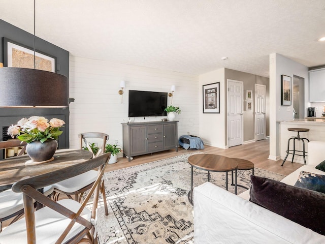 living room with light hardwood / wood-style floors and a textured ceiling