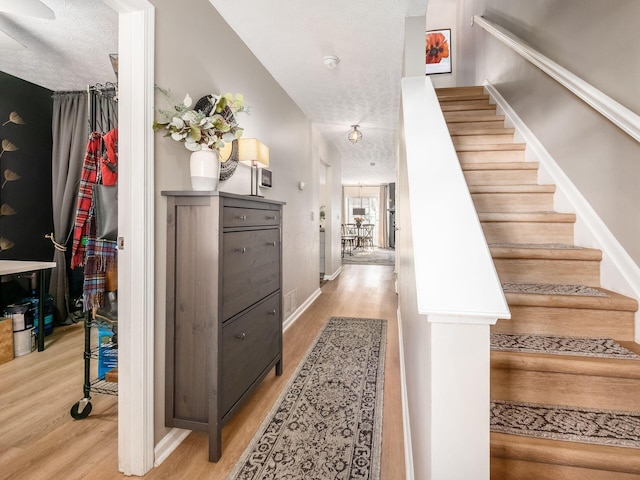 staircase featuring hardwood / wood-style floors and a textured ceiling