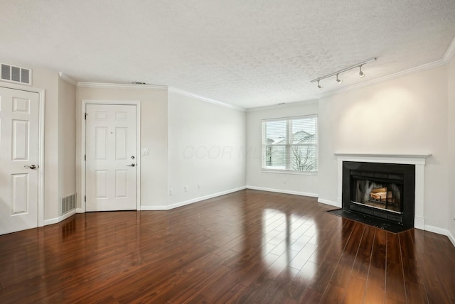 unfurnished living room featuring rail lighting, a textured ceiling, dark hardwood / wood-style floors, and crown molding