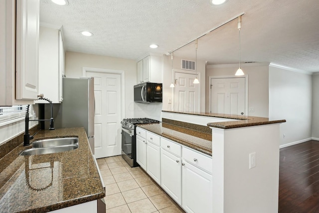 kitchen featuring sink, white cabinetry, stainless steel appliances, and a textured ceiling