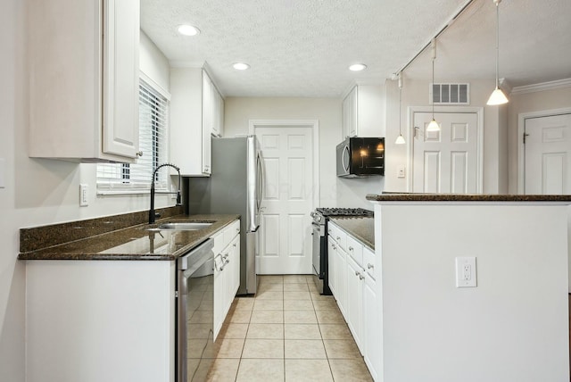 kitchen featuring gas stove, dishwasher, pendant lighting, white cabinets, and sink