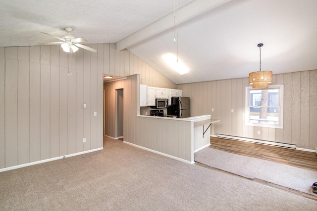 kitchen featuring vaulted ceiling with beams, kitchen peninsula, baseboard heating, pendant lighting, and appliances with stainless steel finishes