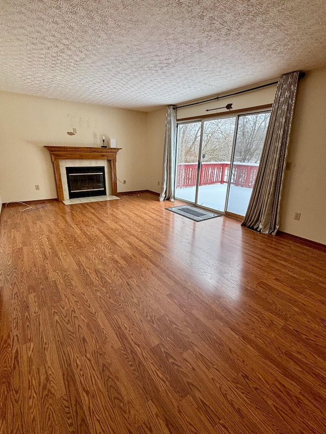 unfurnished living room featuring a fireplace, hardwood / wood-style floors, and a textured ceiling