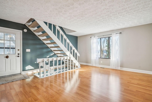 foyer entrance featuring a textured ceiling and hardwood / wood-style flooring