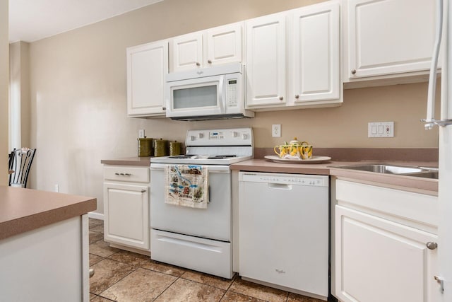 kitchen with light tile patterned flooring, white cabinetry, and white appliances