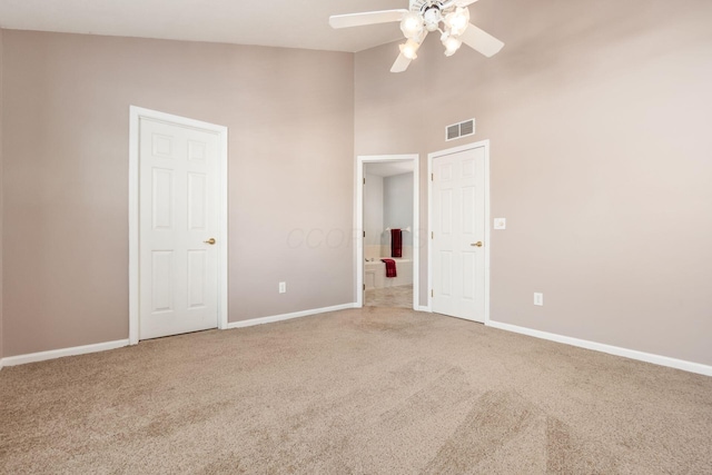 unfurnished bedroom featuring ceiling fan, carpet, and high vaulted ceiling