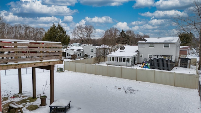 snowy yard with a pergola and a wooden deck