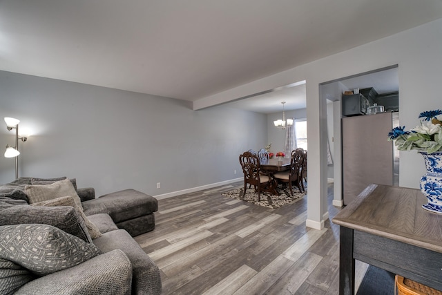 living room with hardwood / wood-style flooring and a notable chandelier