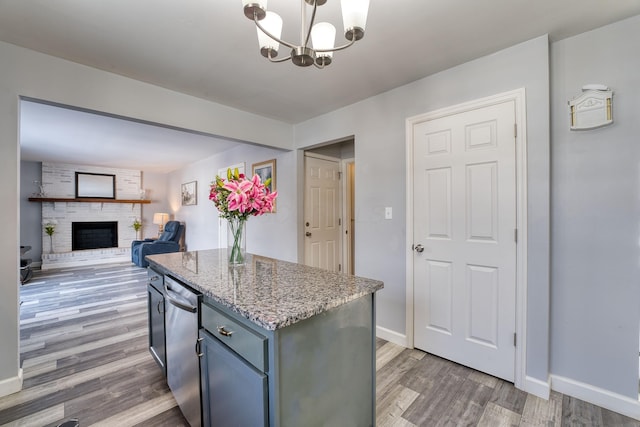 kitchen featuring a center island, decorative light fixtures, a notable chandelier, dark hardwood / wood-style flooring, and a fireplace