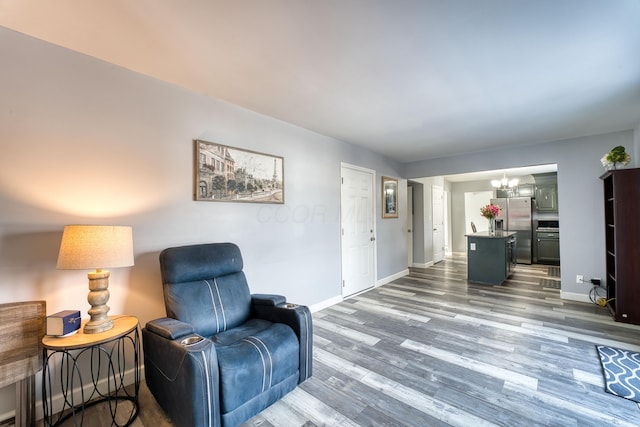 living area featuring wood-type flooring and an inviting chandelier